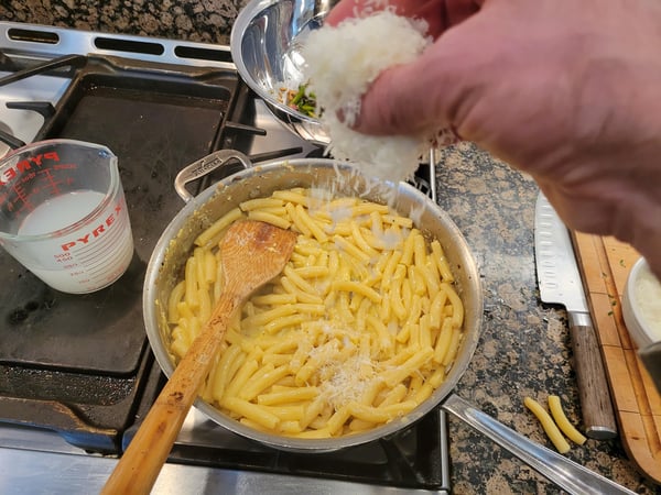 adding cheese to pasta